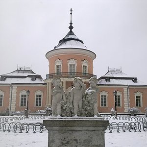 Засніжений фасад Китайського палацу Золочівського замку зі старовинними скульптурами перед входом