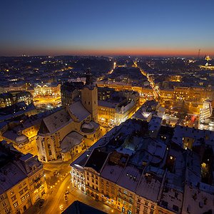 Масштабна панорама вечірнього Львова із запаленими ліхтарями, які освітлюють спокійні вулички міста